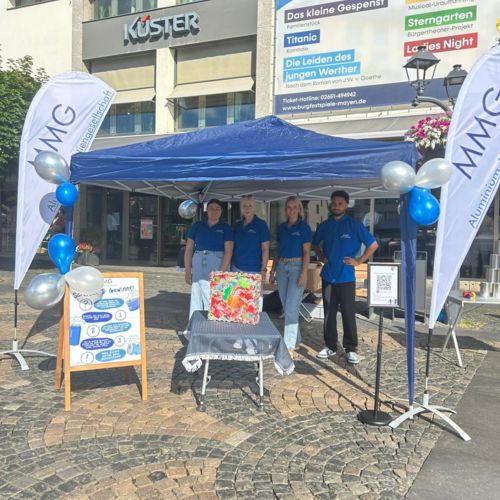 Besucherinnen und Besucher raten die Anzahl von Aluminiumdosen in einem Glasbehälter am MMG-Stand – Recycling als spannendes Mitmachthema.